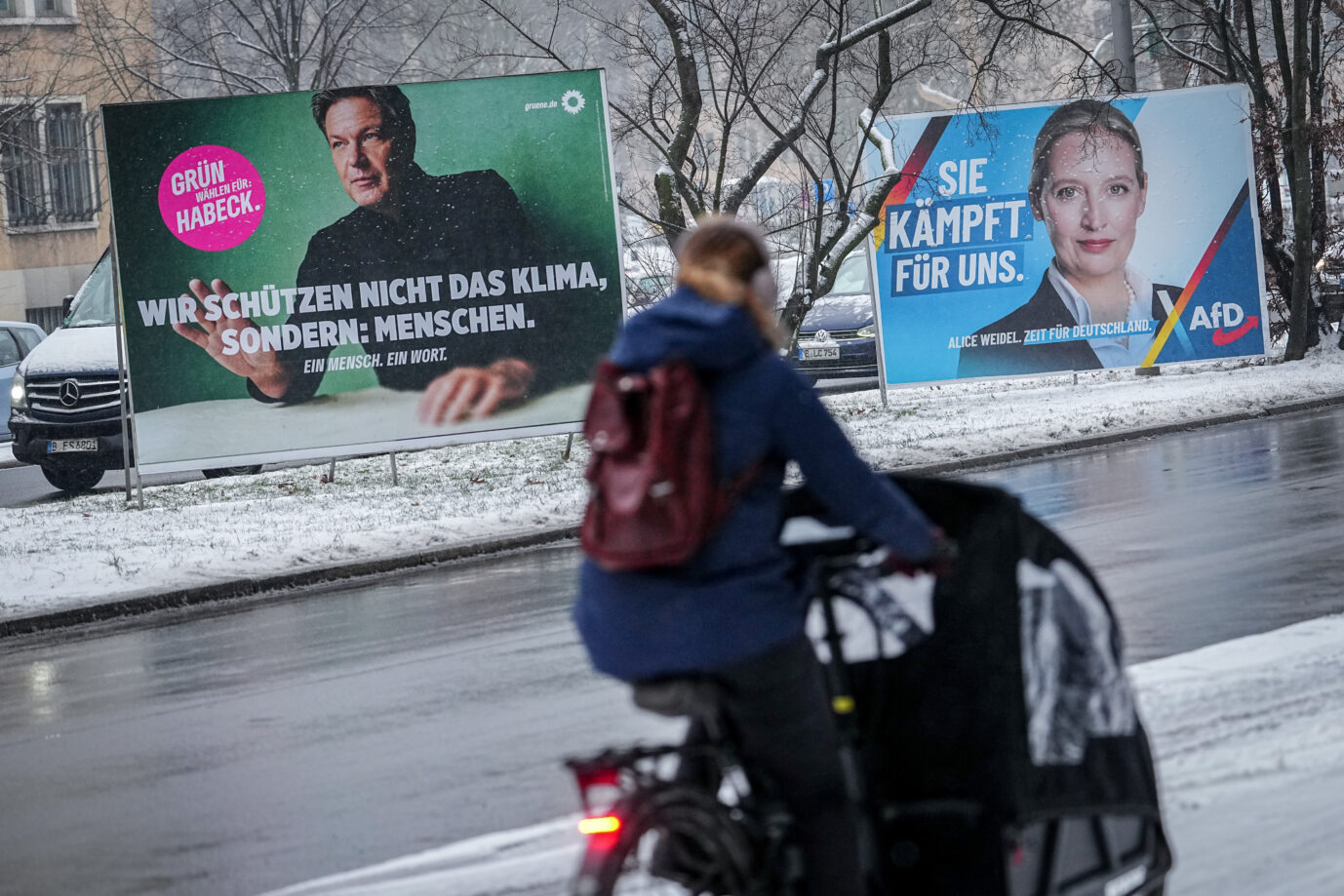 Ein Radfahrer fährt am Morgen an großflächigen Wahlplakaten mit Robert Habeck (Grüne) und Alice Weidel (AfD), Kanzlerkandidaten ihrer Parteien, vorbei. Der Wahlkampf geht aktuell in die heiße Phase.