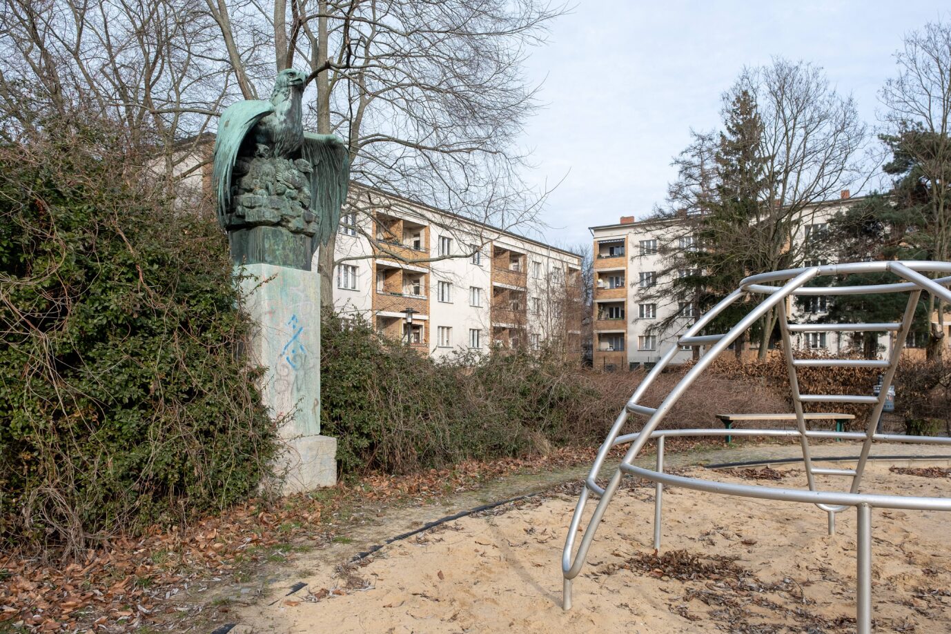 Ein Sandkasten und ein Klettergerüst sind zu sehen, daneben steht die Adlerfigur aus Bronze, um die sich in Berlin-Haselhorst gerade gestritten wird